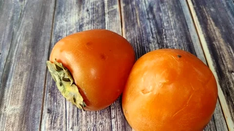 Persimmon on the wooden background Stock Footage 227722089