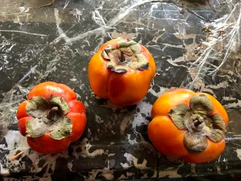 Persimmons on the marble Stock Photos