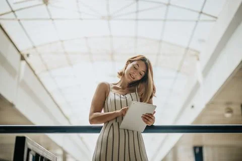 Persistent Businesswoman Solving Problems with Confidence and a Smile Working on 写真素材