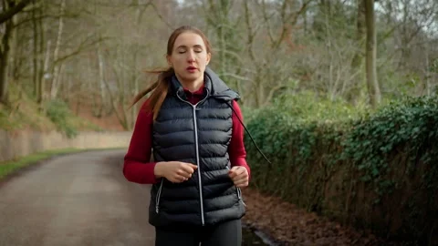 Persistent woman jogging on forest road in countryside. Motivated but tired Stock-Footage 343757385