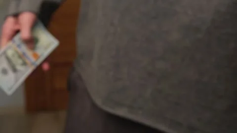 A person accepting a bribe, placing a thick stack of hundred-dollar bills into Stock Footage 303900694