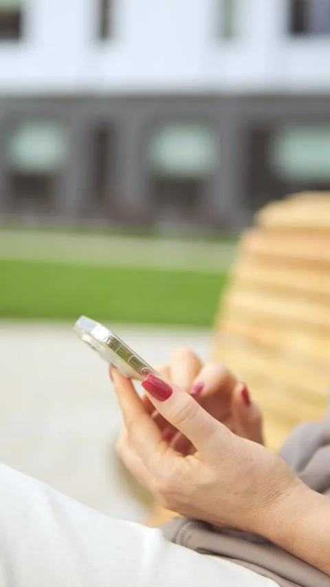 A person is actively engaging with their smartphone while enjoying the outdoors Stock Footage 296729216