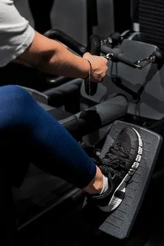 A person is actively rowing on an exercise machine at the gym Stock Photos