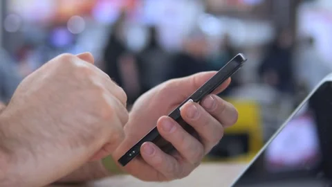 Person actively using phone in busy environment Stockbeeldmateriaal 342588147