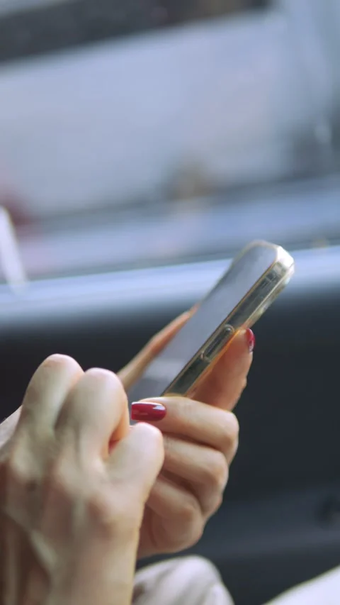 A person is actively using a smartphone while seated comfortably inside a moving Stock Footage 284909192