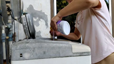 Person Adding Detergent to Laundry in an Old Washing Machine Stock Footage 305164772