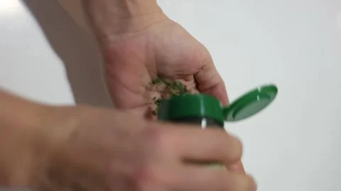 Person adding dried herbs from jar to hand Stock Footage 330111571