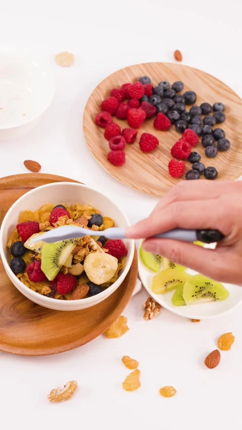 Person Adding Fresh Kiwi Slices to Healthy Yogurt Breakfast Bowl Stock Footage 337691044