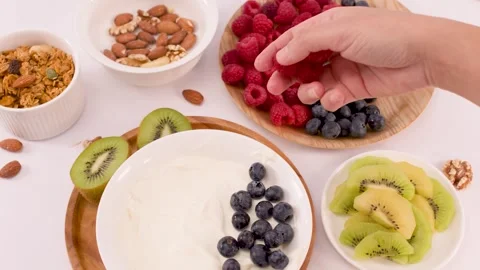 Person Adding Fresh Raspberries to a Healthy Greek Yogurt Bowl Stock Footage 337757264
