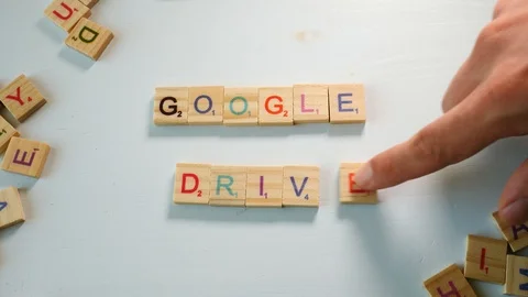 A person adding the letter E to the sentence Google Drive with wooden Stock Footage 104411746
