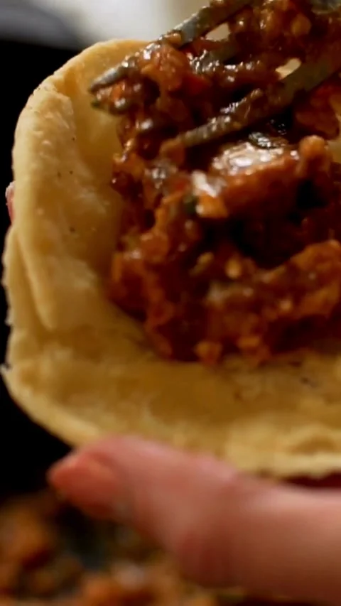 Person adding meat filling to soft taco shell Stock Footage 334170516