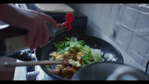 Person Adding Sauce to Asian Stir Fry in Home Kitchen Stock Footage 341575763
