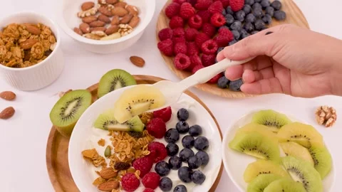 Person Adding Sliced Kiwi to a Healthy Greek Yogurt Fruit Bowl Vídeo Stock 337767698