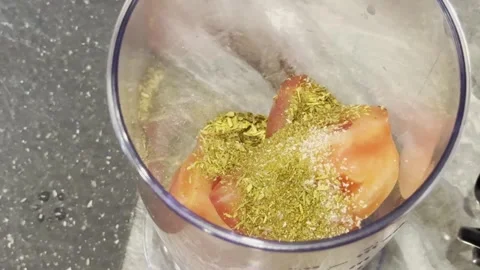 A person is adding spices to a blender full of food Video stock 279299142