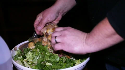 Person adding toasted croutons to a green salad Stock Footage 153521882