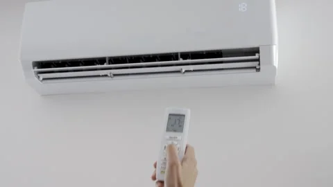Person adjusting air conditioner temperature with remote control Stock Footage 336940786