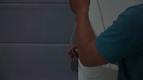Person adjusting a roller curtain for better sunlight exposure. Stock Footage 338192152