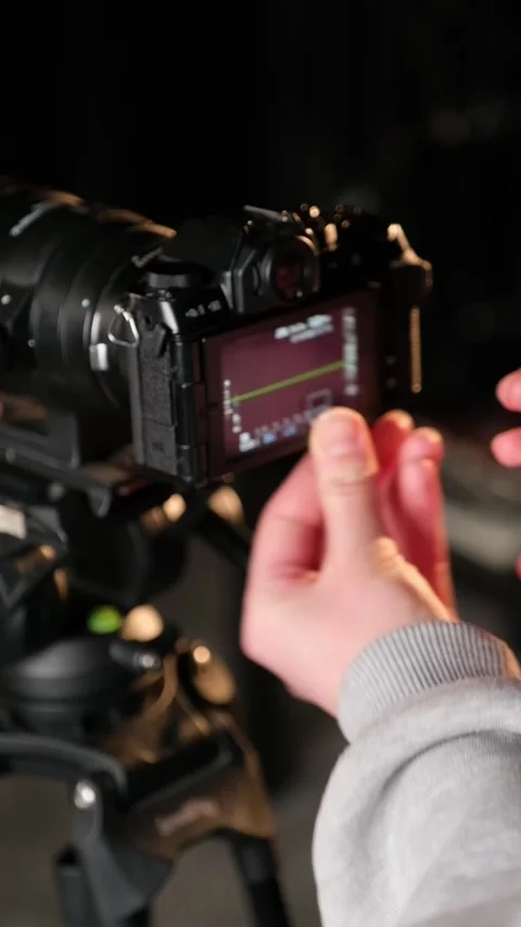 Person adjusting settings on professional camera Stock Footage 306779859