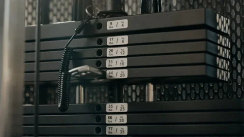 Person Adjusting Weight Stack Pin for Strength Training in Gym Stock Footage 345206398