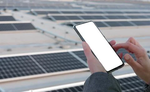 Person analyzing data on mobile phone through photovoltaic panel while working i Stock Photos