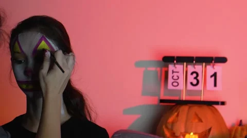 A person is applying makeup to their face in preparation for Halloween Stock Footage 319825371