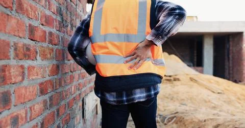 Person, architect or hands with back pain on construction site for overworked Stock Photos