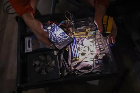 Person assembling high performance gaming PC with glowing components Stock Photos