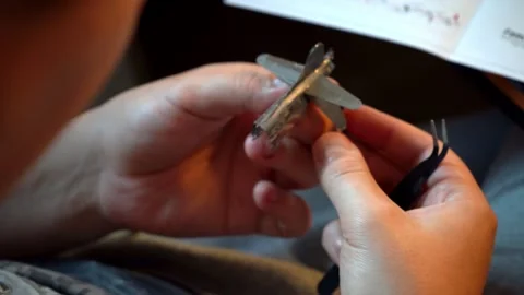 Person assembling metal airplane model with hands Stock Footage 319294040