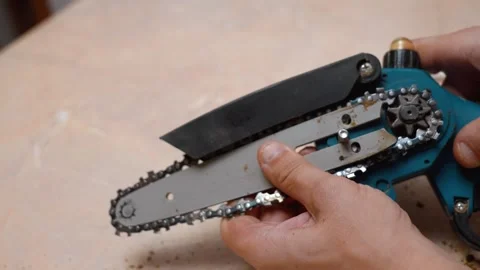 Person assembling a mini electric chainsaw blade Stock Footage 327158371