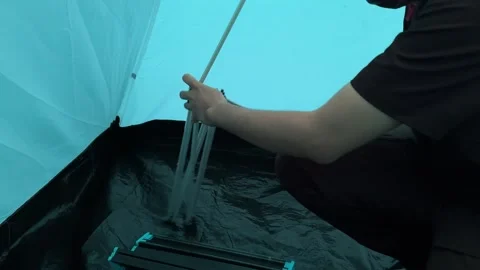 Person Assembling Portable Camping Table Inside Tent, Medium Shot Stock Footage 323585764