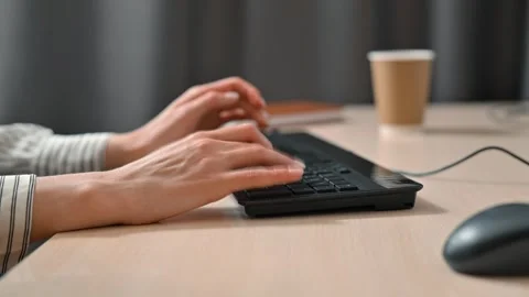 A person is attempting to type on a broken keyboard while sitting at a desk. A Stock Footage 339005657