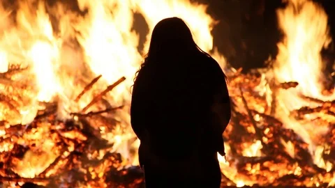 Person attempts to stand in front of fire until it burns too much Stock Footage 122803796