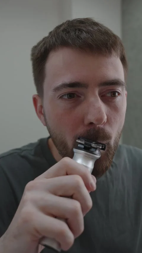 Person attentively uses tools to refine their beard shape confidently Vídeo Stock 333332109