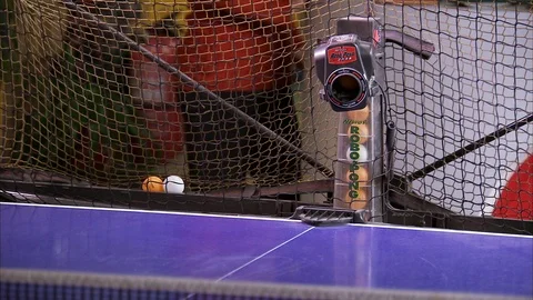 Person beats balls that shoot machine on table tennis Video stock 88833411