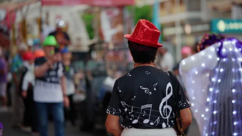 Person from behind with red sequin hat and music note shirt participating in a 库存影片 339809114