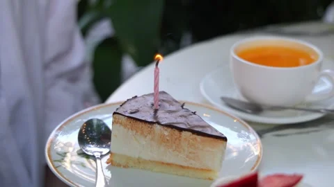 Person Blowing Out Magic Trick Candle on Birthday Cake Slice Stock Footage 342602639