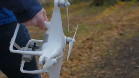 A person in a blue jacket goes with a drone through the forest in slowmotion Stock Footage 87796498