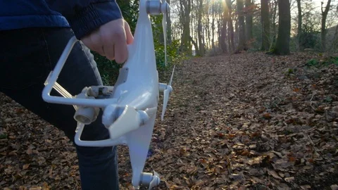 A person in a blue jacket goes with a drone through the forest in slowmotion Stock Footage 89959266