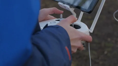 A person in a blue jacket is using a radio remote control Stock Footage 87273974