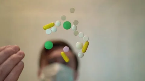 Person on the blurred background in slow motion throws the pills on a table Stock Footage 130190458