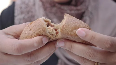 A person breaking a warm piece of bread in a cafe setting Stock Footage 337446668