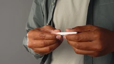 Person breaks thin white object into two pieces. Stock Footage 332194902