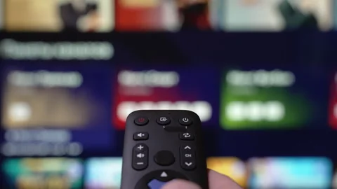 Person Browsing Streaming Services Using Remote Control. Hand Holding a Remote Video stock 305374261