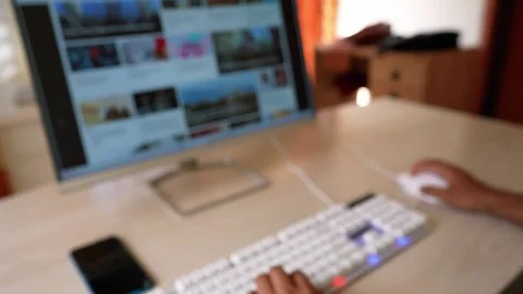 Person Browsing Website on Computer, Person using a computer with a blurred.. Stock Footage 317736908