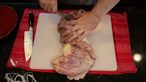 Person butchering beef meat in the kitchen with a knife Video stock 141237409