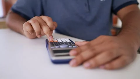 Person Calculating and Writing Notes, Person using a calculator and writing.. Stock Footage 317736993