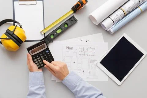 Person calculating construction plan with tools and tablet Stock Photos