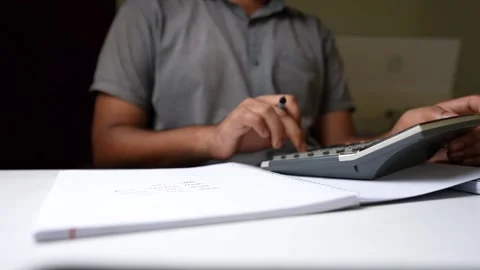 Person Calculating with Notebook on Desk Stock Footage 320725068
