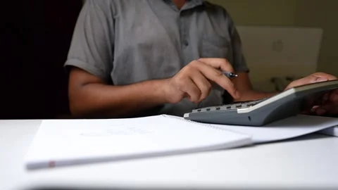 Person Calculating with Notebook on Desk Stock Footage 320725086