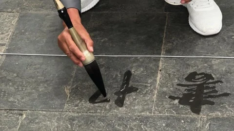 Person calligrapher practicing water calligraphy on stone Stock Footage 339789991